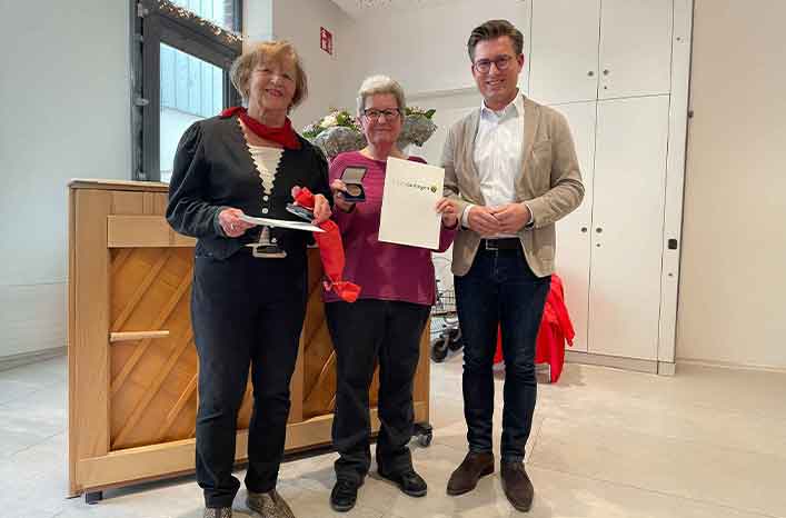 Ehrung im Freizeitclub Gerlingen: Zwei engagierte Frauen präsentieren stolz ihre Urkunde und Medaille neben einem offiziellen Vertreter in einem hellen Festsaal.